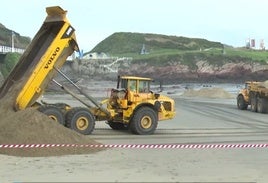 Camiones depositando la arena en la playa de Salinas.