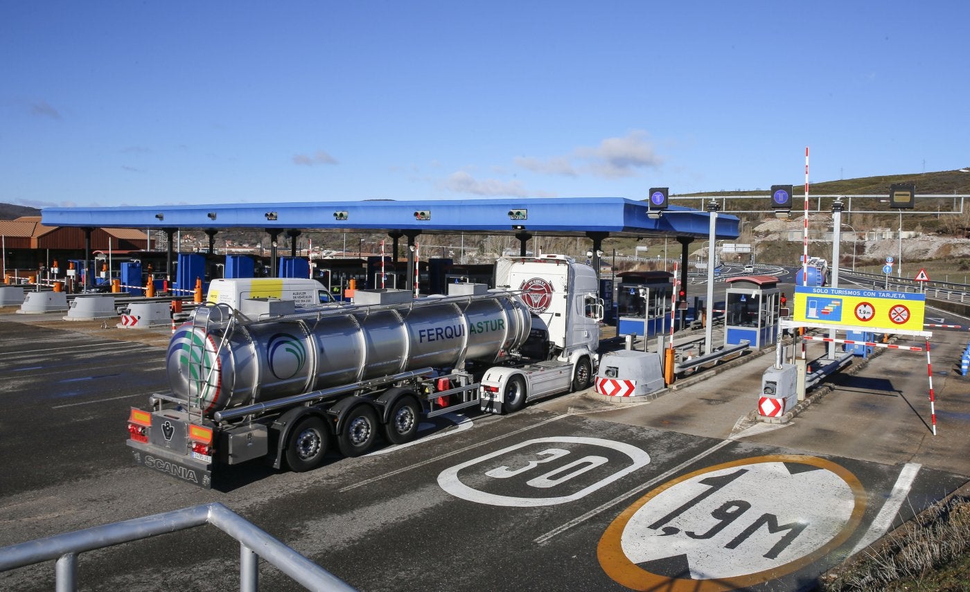 Un camión de transporte alimentario y una furgoneta industrial pasan por el peaje de La Magdalena, en la autopista del Huerna (AP-66).