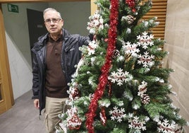 Juan Fernández posa con el árbol de Navidad con los nombres de los vecinos.