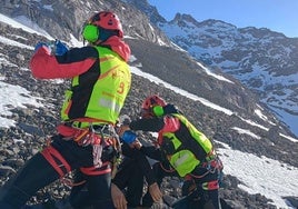 Dos efectivos del Servicio de Emergencias del Principado de Asturias atienden al joven al que se le buscaba en Picos de Europa.