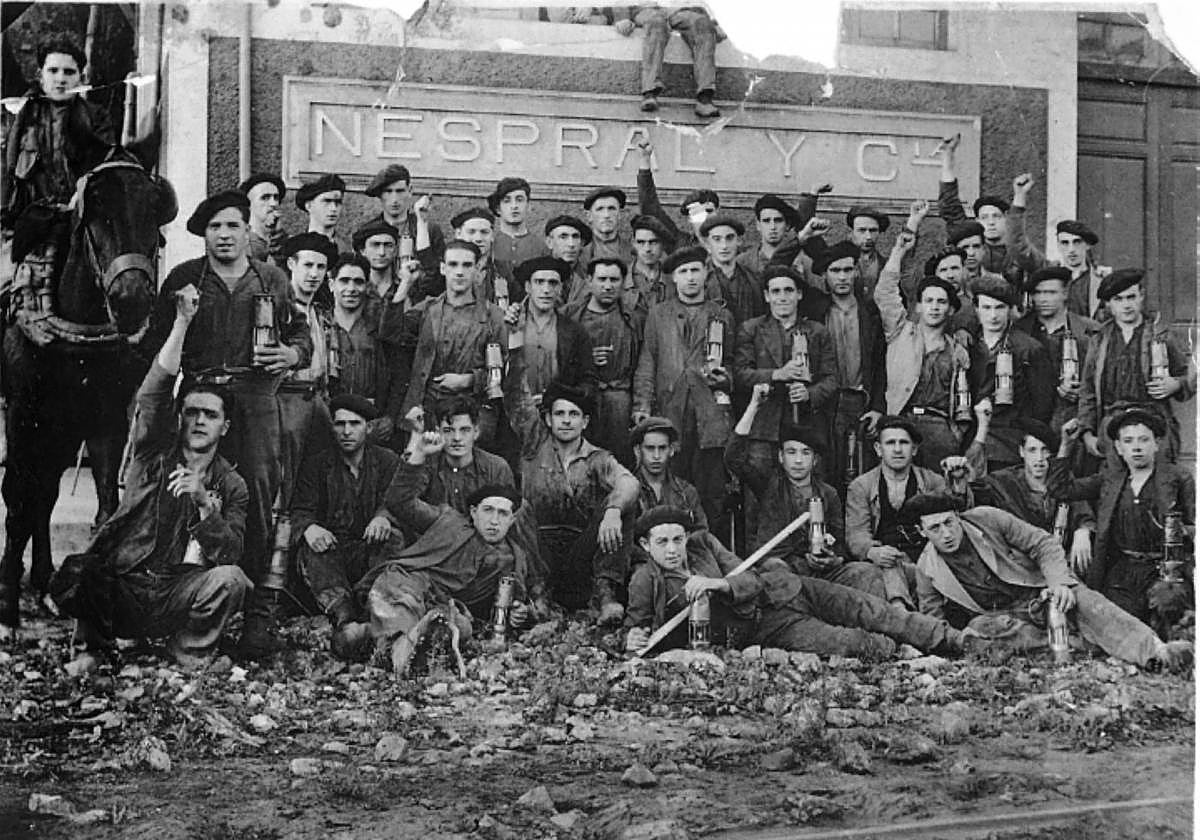 Grupo de mineros con el puño en alto en 1934, a la entrada del Pozo Entrego de Nespral y Cía.