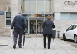 Dos personas mayores acceden al centro de salud de El Llano, en Gijón.