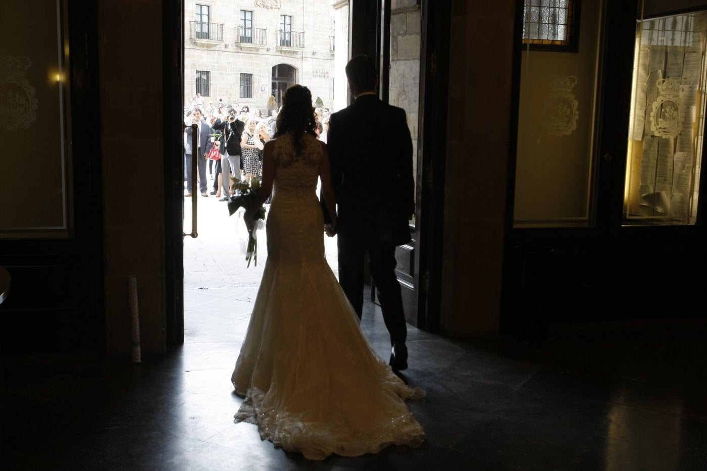 Una pareja de recién casados salen del Ayuntamiento después de su boda.