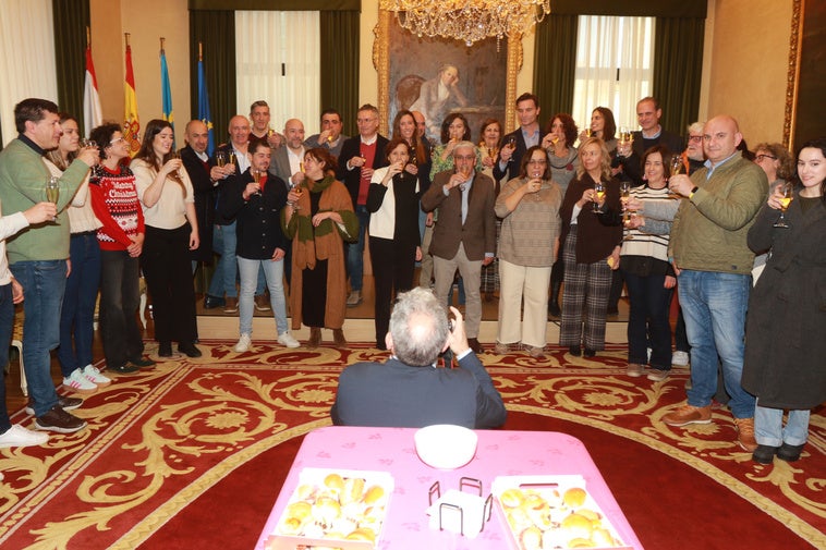 La alcaldesa, Carmen Moriyón, en el centro, con el resto de miembros de la Corporación municipal y representantes de los medios de comunicación en el brindis navideño.