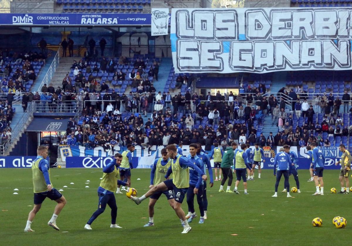 Los jugadores del Oviedo, durante el entrenamiento en el Tartiere a puertas abiertas, con una pancarta de fondo que reza 'Los derbis se ganan'.