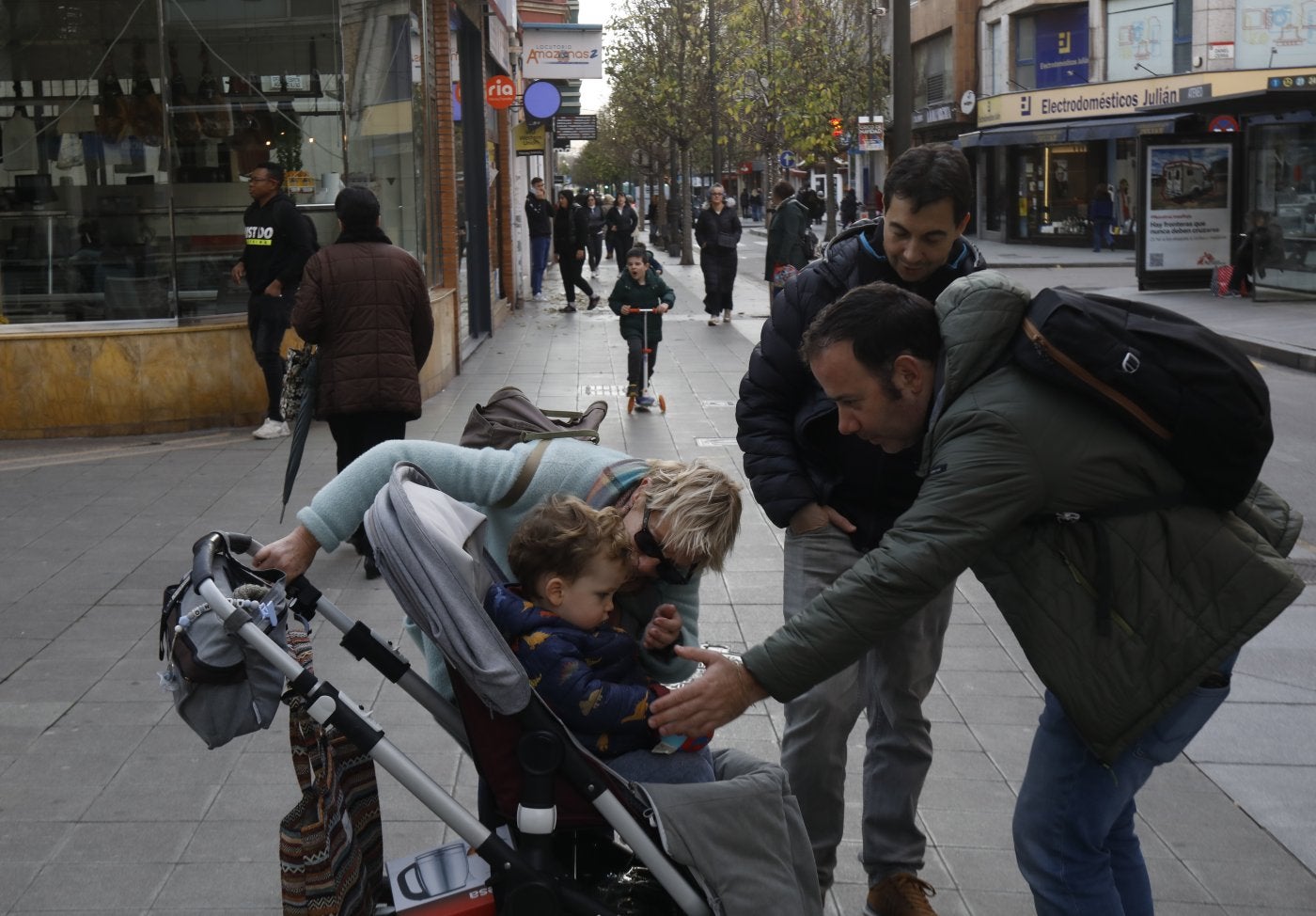 Vecinos con un carrito infantil por la avenida de la Argentina, en La Calzada, uno de los barrios que creció.