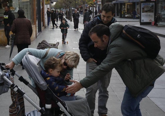 Vecinos con un carrito infantil por la avenida de la Argentina, en La Calzada, uno de los barrios que creció.