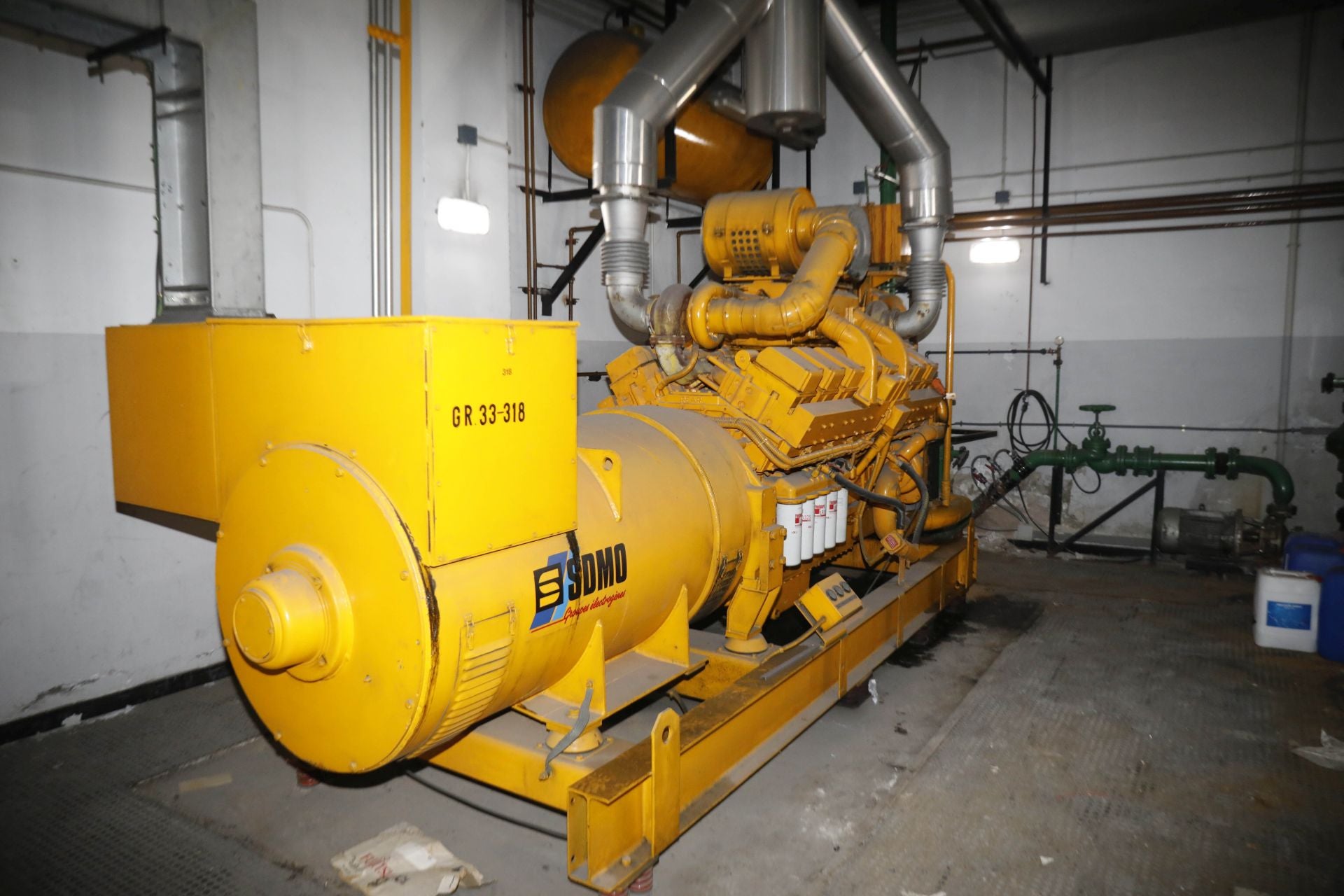 Imagen secundaria 1 - Arriba, la azotea del inmueble con la antena de telefonía que se conservará. A la izquierda, grupo electrógeno diésel en planta baja que deberá ser desalojado. A la derecha, los cuadros eléctricos ubicados en la planta baja que ocupan mucho espacio. 