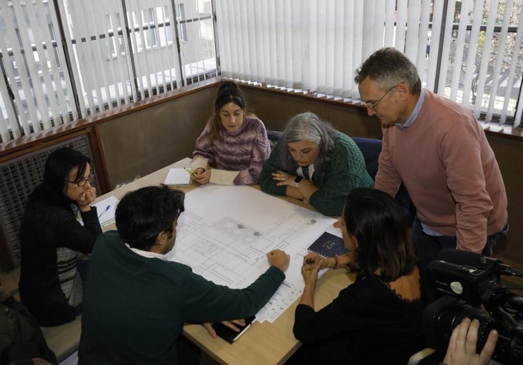 El edil de Obras Públicas de Gijón, Gilberto Villoria (de pie) y técnicos del área estudian con la dirección del Rey Pelayo los planos del colegio.