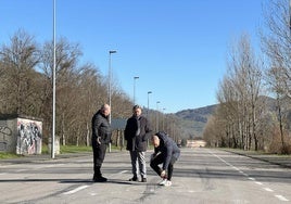 El inspector de la Policía Local de Oviedo Diego Cortina recoge un trozo de neumático del asfalto en la recta donde se producen las carreras ilegales de velocidad los fines de semana.