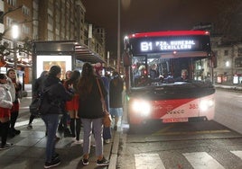 Pasajeros esperando a uno de los búhos que circulan actualmente por Gijón.