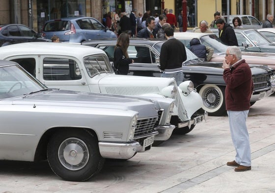 Un hombre observa un coche antiguo.