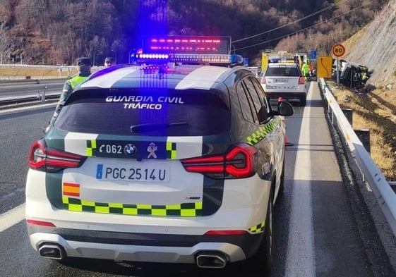 Dos patrullas de la Guardia Civil y el camión accidentado, al fondo.