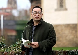 El escritor, en el entorno de la iglesiaprerrománica de Santullano, en Oviedo,con su libro.