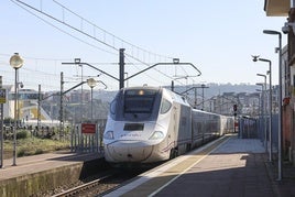 Un Alvia entrando en la estación de Avilés con el Niemeyer al fondo.