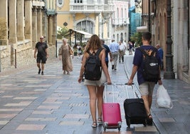 Turistas con sus maletas bajando la calle Galiana.