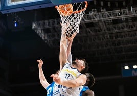 El ala-pívot del Alimerka Oviedo Baloncesto Marc Martí anota bajo canasta pese a la oposición de dos rivales.
