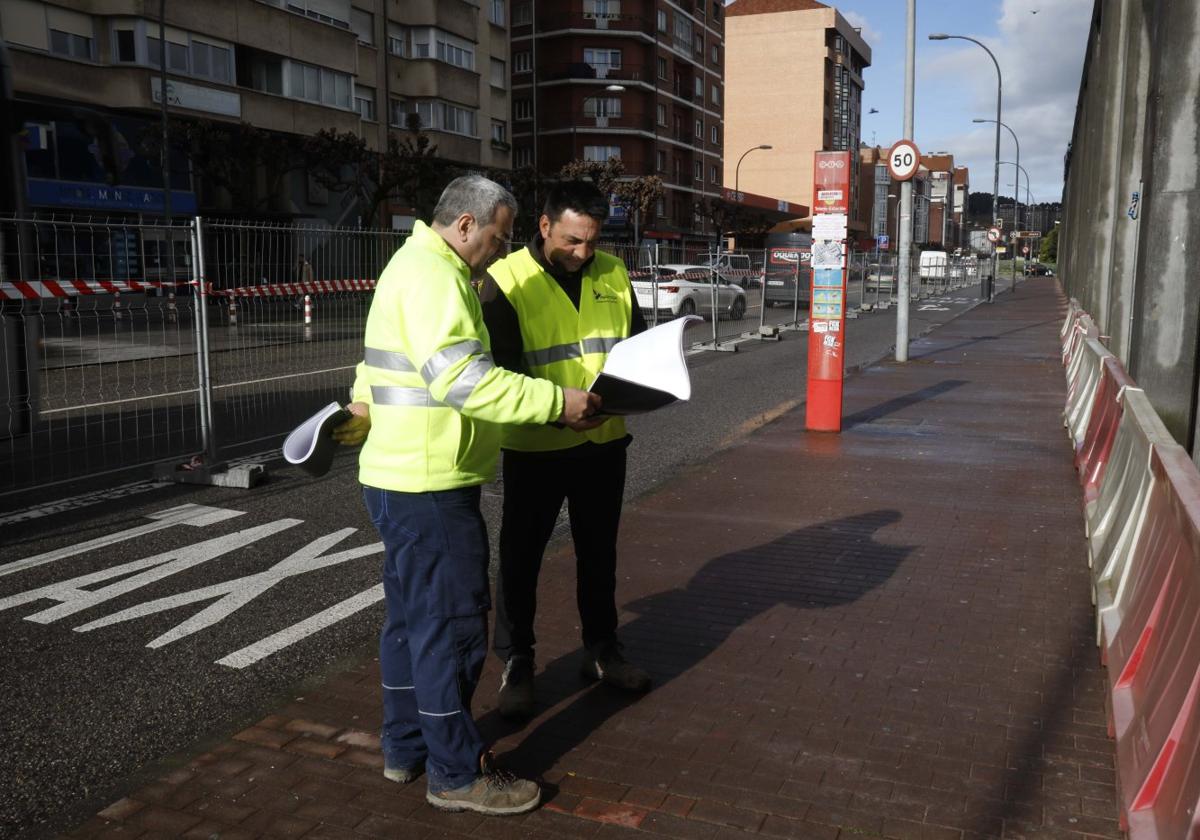 Dos trabajadores junto a la parada de autobús anulada por las obras del intercambiador de la avenida de Los Telares de Avilés.