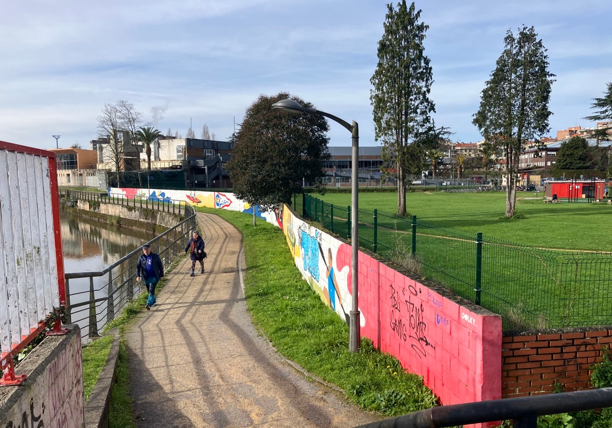 Muro de la senda del Piles anexo a la finca La Torriente, con grafitis alusivos a las piraguas del Grupo Covadonga, que será derribado para ampliar el paseo peatonal y ciclista en ese tramo.