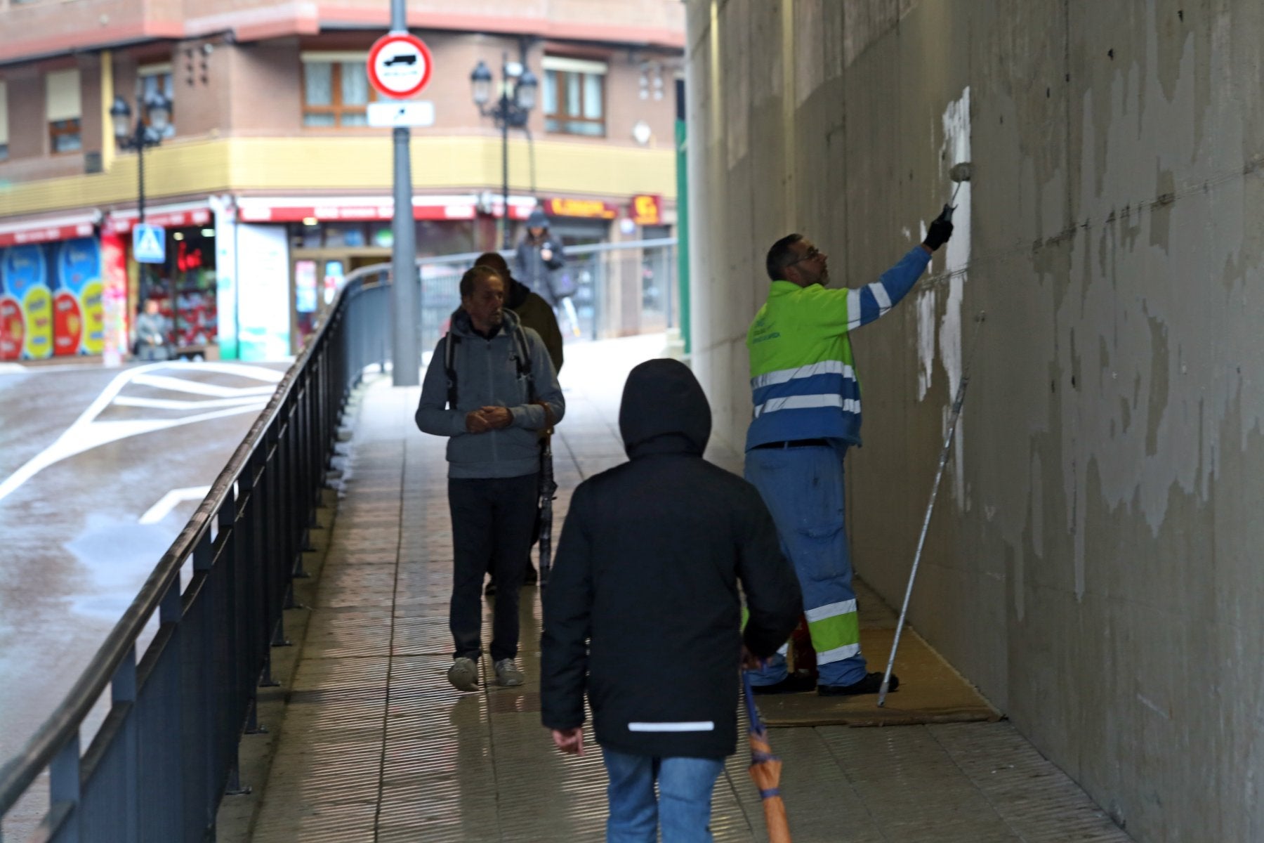 Un operarios tapa la pintada en el paso de Nicolás Soria.