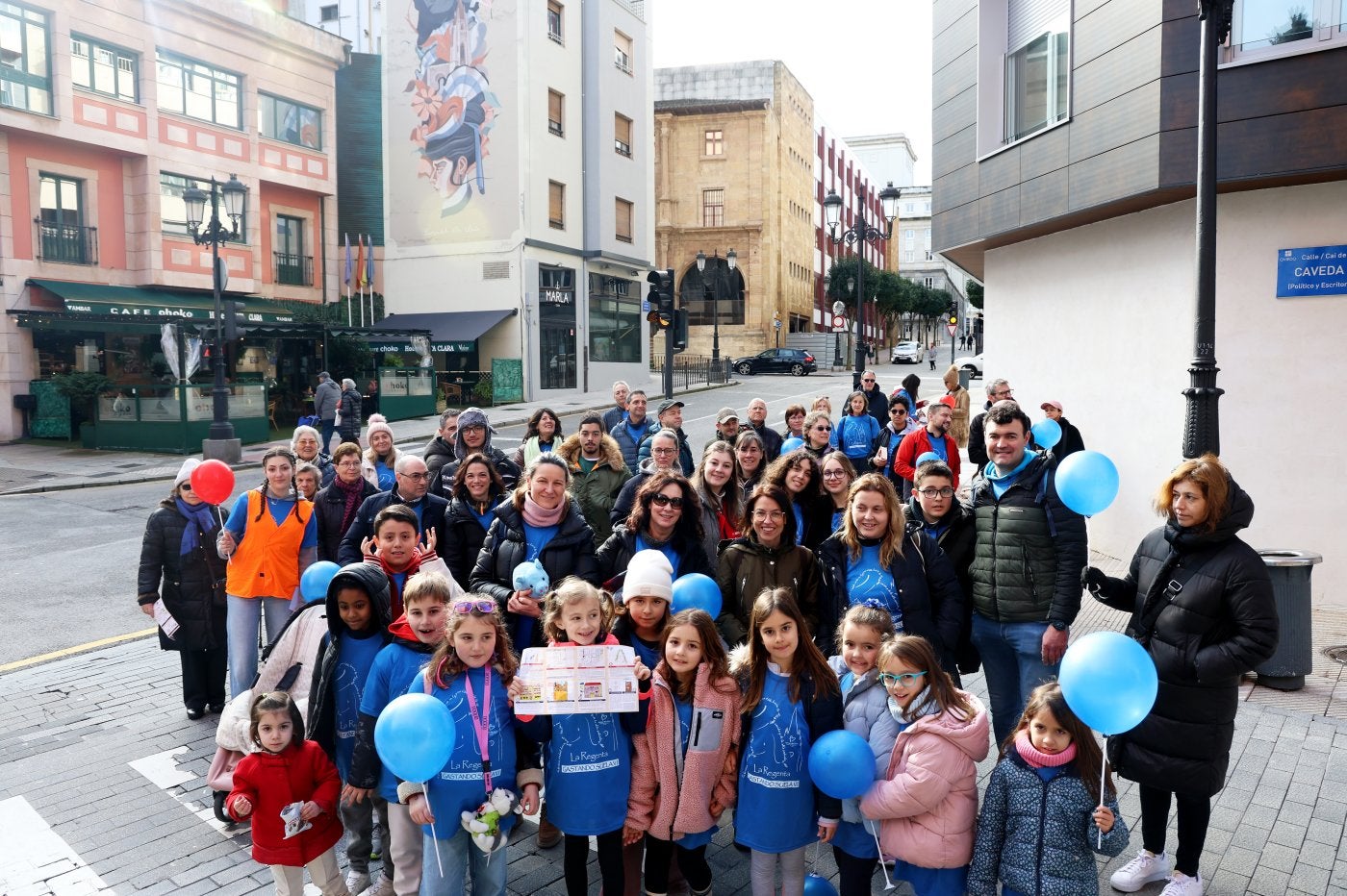 Un grupo de participantes, con el mural dedicado a Clarín al fondo. Tres participantes caracterizados para la carrera.El puesto en el colegio Amor de Dios.