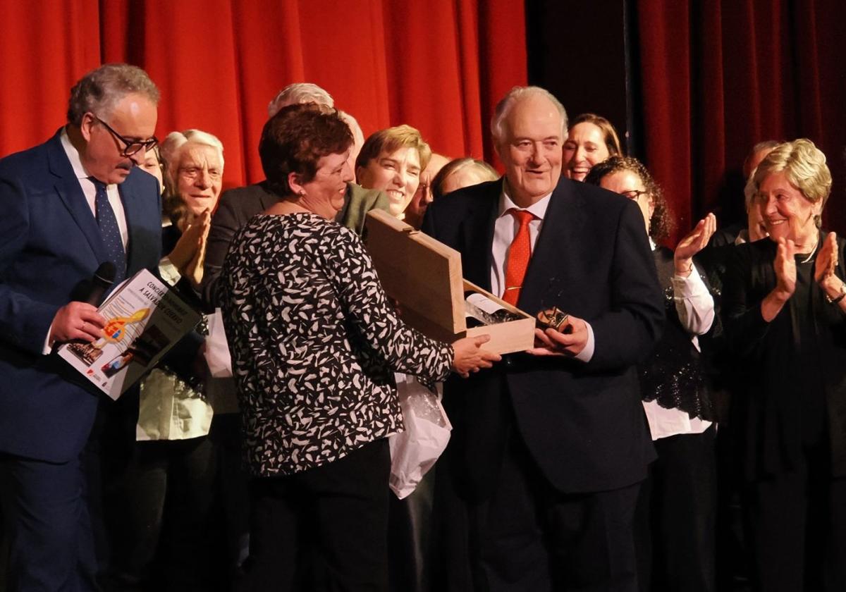 Salvador Cuervo recibe un premio de manos de Isabel Santano, presidenta del Coro de la Bodega de Candás.