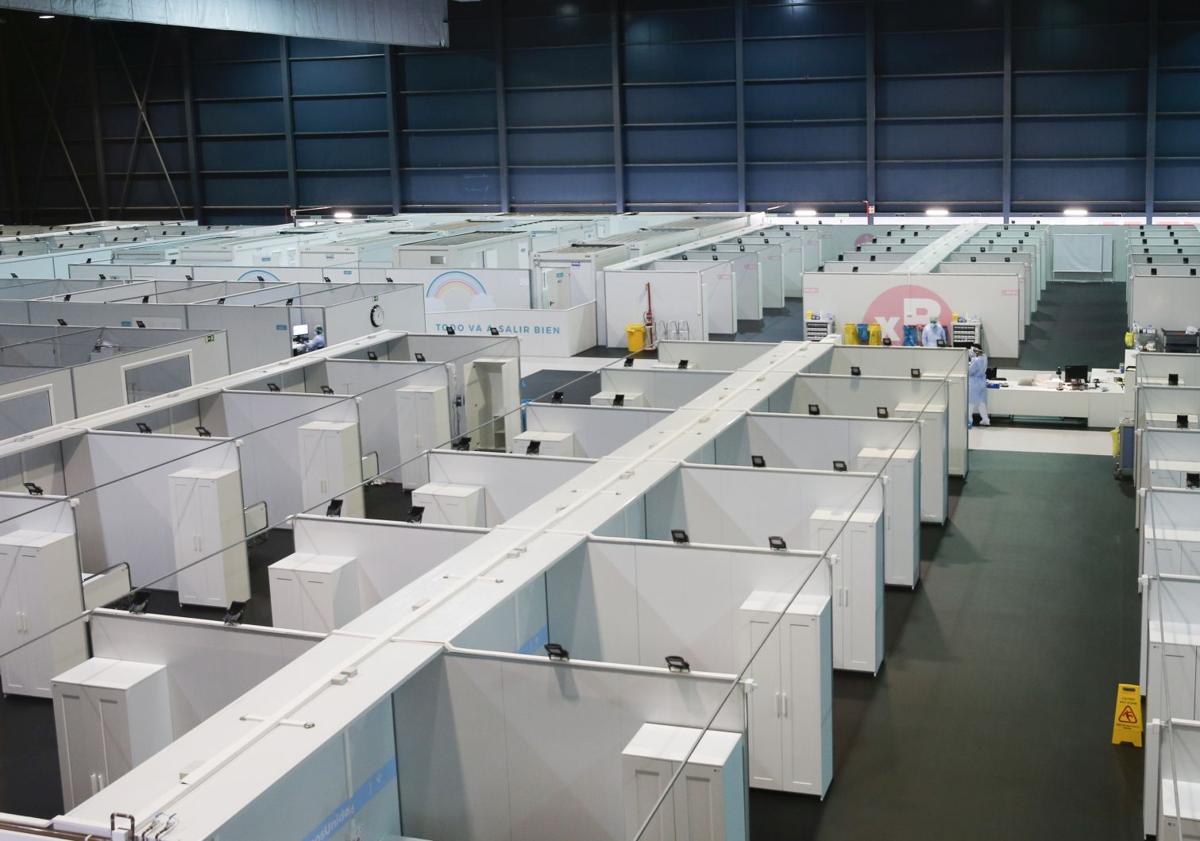 Imagen principal - Imagen 1: Gijón. Imagen del hospital habilitado en la Feria, antes de su entrada en funcionamiento. Imagen 2: Cabueñes. Tres profresionaes sanitarios, en pleno trabajo en la UCI gijonesa. Imagen 3: UME. Un militar, en el Hospital de Campaña de Oviedo. 
