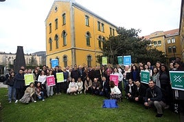El rector, en el centro, agachado, junto a los estudiantes, ante el árbol plantado como recuerdo.