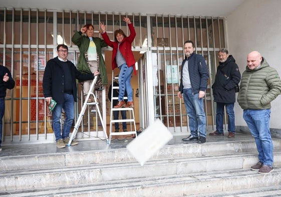 Evelia Muñiz y Mercedes García arrojan la placa mientras Jaime Capellán sostiene el destornillador eléctrico.