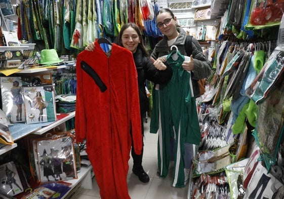 Dos clientas posan en la tienda de regalos Molino con los disfraces de 'El juego del calamar' que llevarán los próximos días.