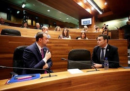 El presidente del Principado de Asturias, Adrián Barbón, conversa con el consejero de Hacienda, Guillemo Peláez, en la Junta General.