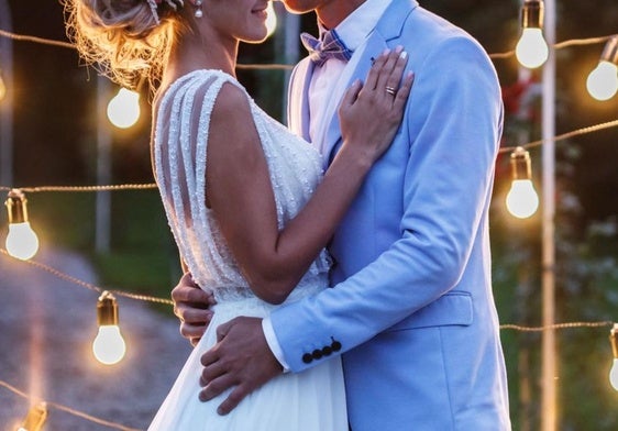Una pareja de recién casados se besan durante la boda.