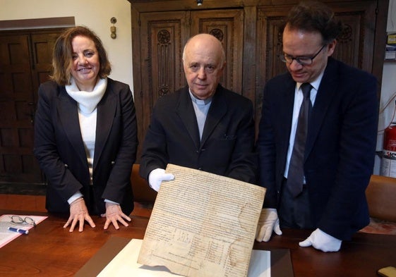 Otilia Requejo, Juan José Tuñón y Miguel Calleja muestran el acta de apertura del Arca Santa, de 1075.