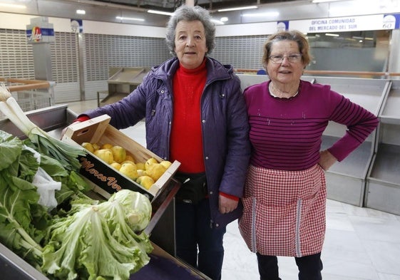 Las hortelanas Inmaculada Fernández y Bernarda López muestran lo que traen para vender a la planta bajocubierta del Mercado del Sur de Gijón.