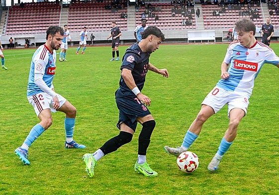 Nico Fernández intenta irse de dos rivales en el partido del Avilés en Compostela.