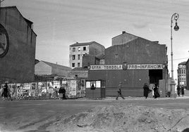 Tómbola de la rifa Pro-Infancia y la techumbre del hórreo en el solar donde se hizo Correos. La calle todavía no se había ensanchado y se ven los caserones. Fecha: 1925.