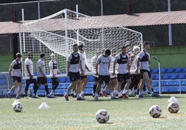 Los jugadores del Real Avilés recogen una portería móvil durante uno de los entrenamientos de la semana en La Toba 2.
