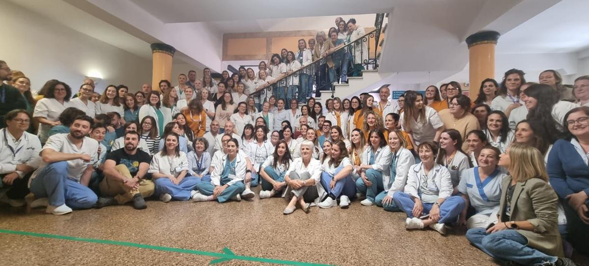 Marlén García, sentada en el suelo, en el centro, y rodeada de compañeros en su último día de trabajo.