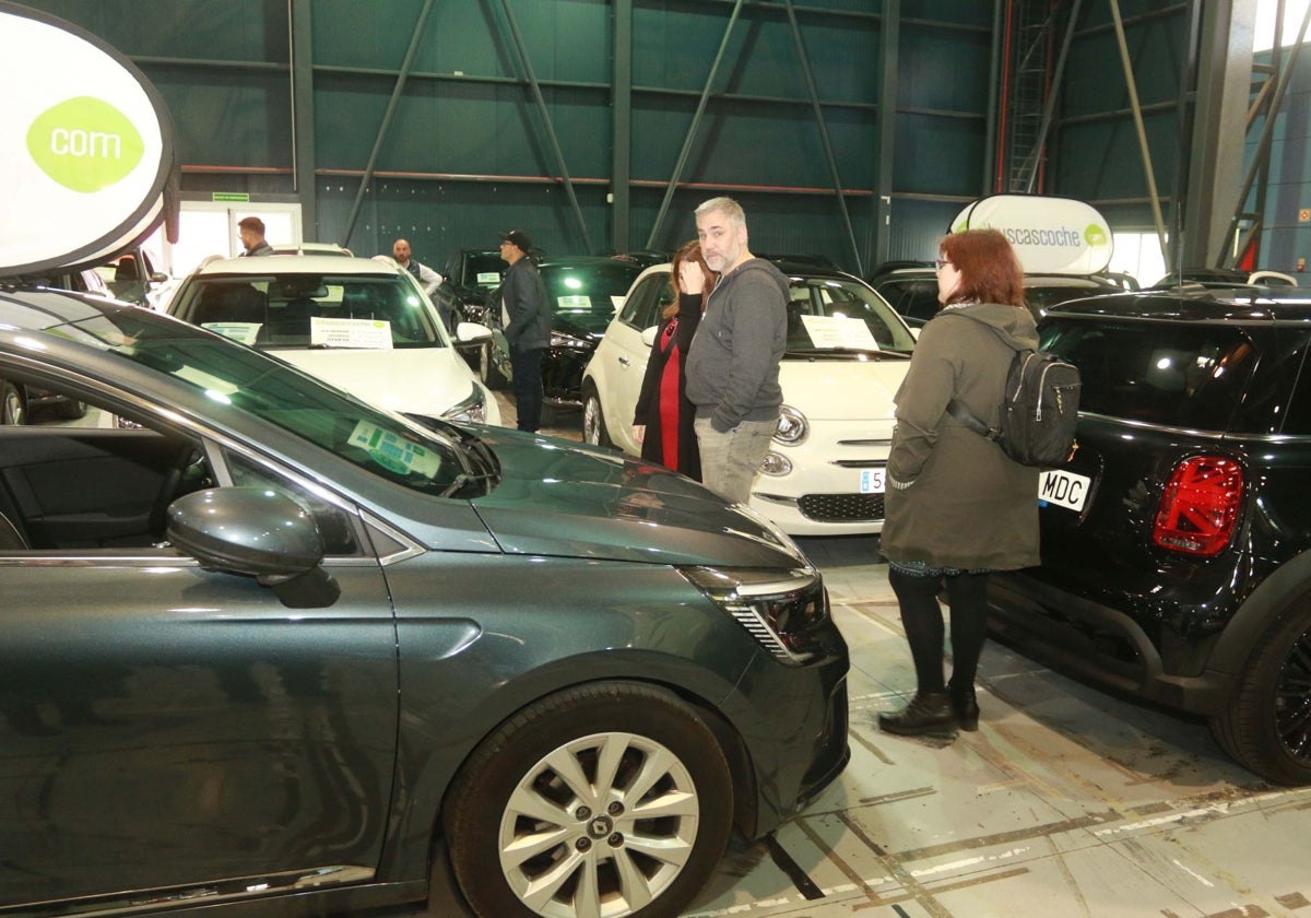 Participantes en la cita del motor en el recinto ferial observan diferentes modelos de turismos.