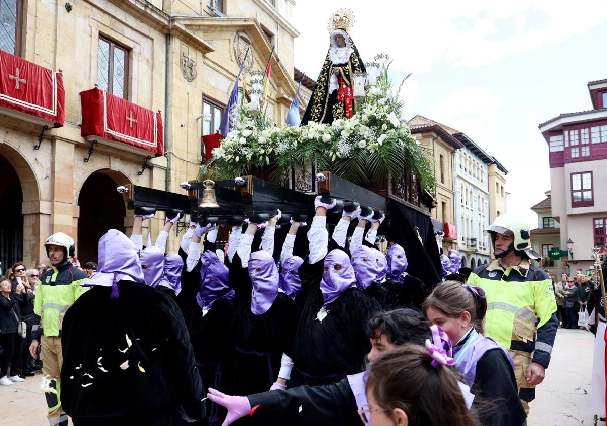 Los porteadores levantan a pulso a la virgen de la Soledad en la plaza del Ayuntamiento.