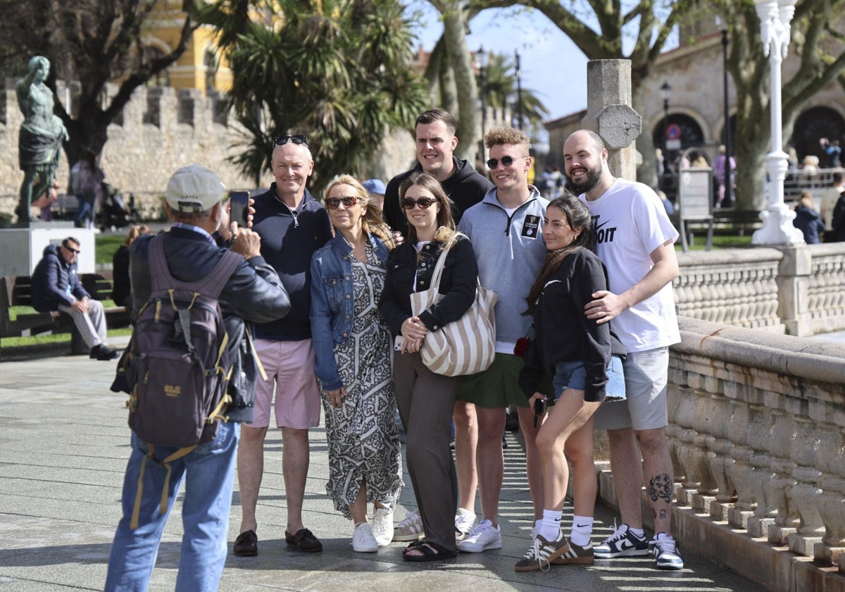 Una familia de turistas se fotografía junto al Campo Valdés, en Gijón.