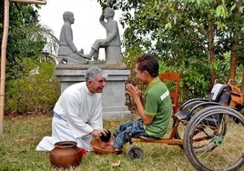 El jesuita Kike Figaredo asiste a un camboyano discapacitado.