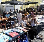 Valentina y Lía junto a sus puestos de libros en el espacio Kuivi Almacenes.