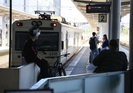 Viajeros esta mañana a la espera de coger un tren en la estación de Gijón.