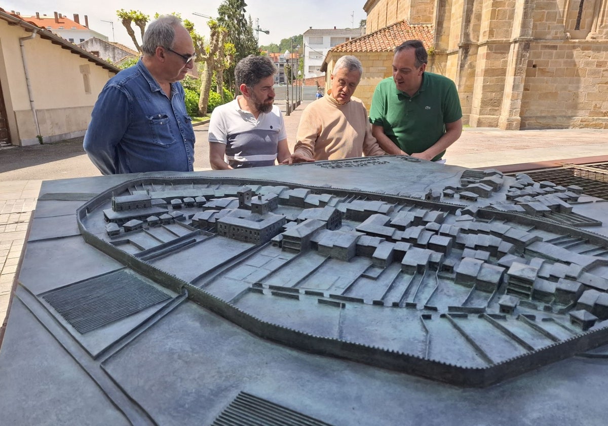 Fernando Capa, de la empresa de fundición Capa Escultura; Juan Antonio González, presidente de la Mancomunidad de la Comarca de la Sidra; Xuan Pedrayes, arquitecto diseñador de la maqueta; y Alejandro Vega, alcalde de Villaviciosa, observan la maqueta de bronce recién instalada en la plaza