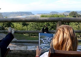 Turistas disfrutando de las vistas desde un hotel rural de Villaviciosa.