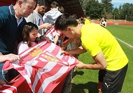 Gaspar Campos firma una bandera del Sporting.