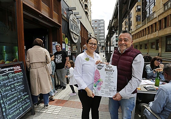Emilio Rubio, propietario de La Montera Picona y una de las camareras muestran la carta del menú del Día de la Madre.