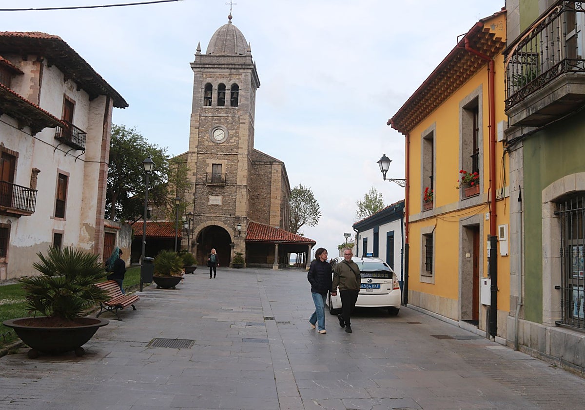 Los vecinos de Luanco caminando cerca de la iglesia de Santa María de Luanco.