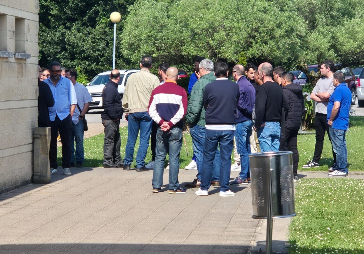 Compañeros del trabajo de  la víctima se dan apoyo delante del tanatorio de Cabueñes